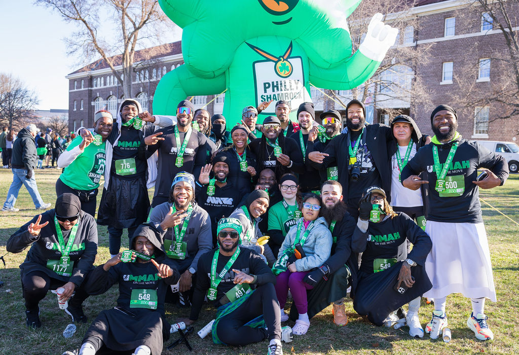 Group of runners celebrating with medals at the finish line of the 2026 Philly Shamrock Run in Philadelphia